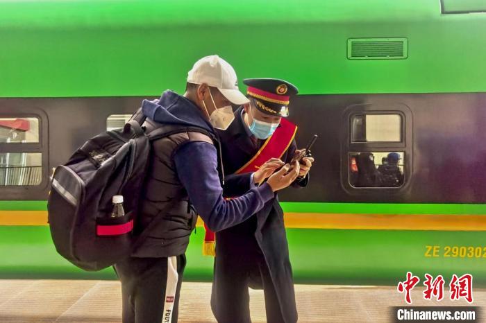 圖為日喀則火車(chē)站工作人員服務(wù)乘客?！《飞降?攝