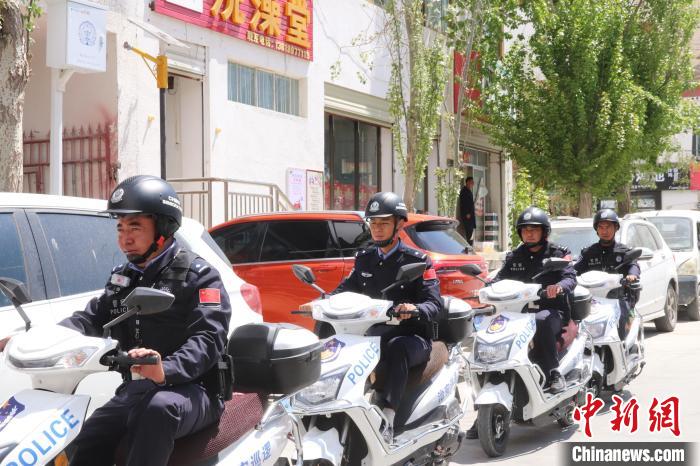 民警騎著電瓶車在轄區(qū)巡邏走訪。　黃創(chuàng)偉 攝