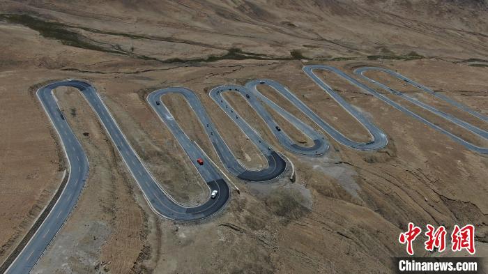 圖為騎手前往珠峰大本營途經(jīng)108道拐?！∮文恋厍蚬﹫D