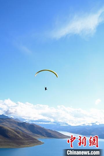 圖為在羊卓雍錯，游客體驗高空滑翔?！≮w朗 攝