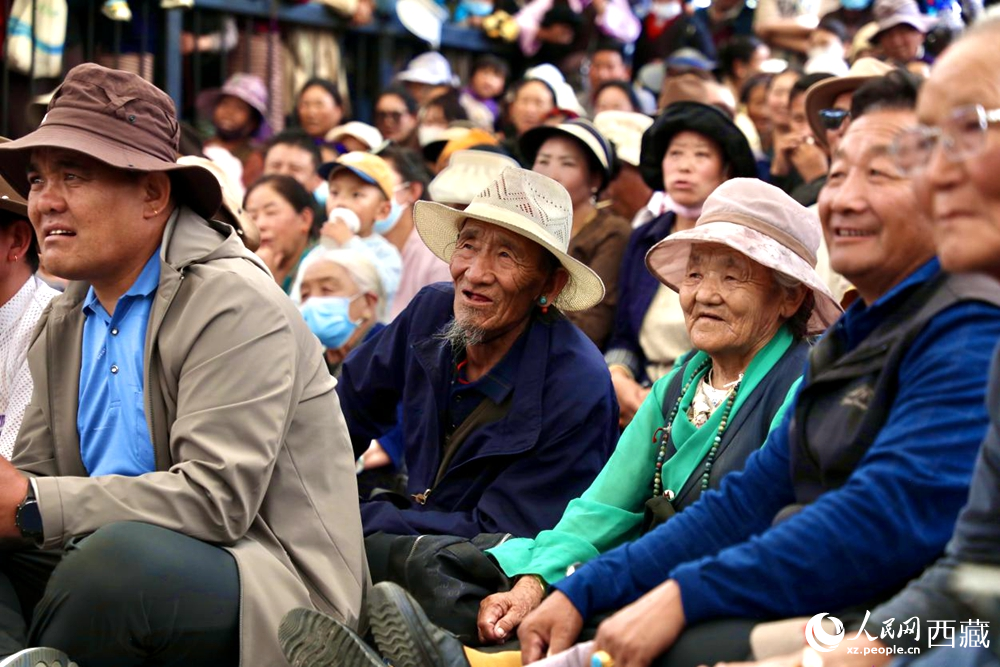 當(dāng)?shù)厝罕姾陀慰陀^看藏戲演出。