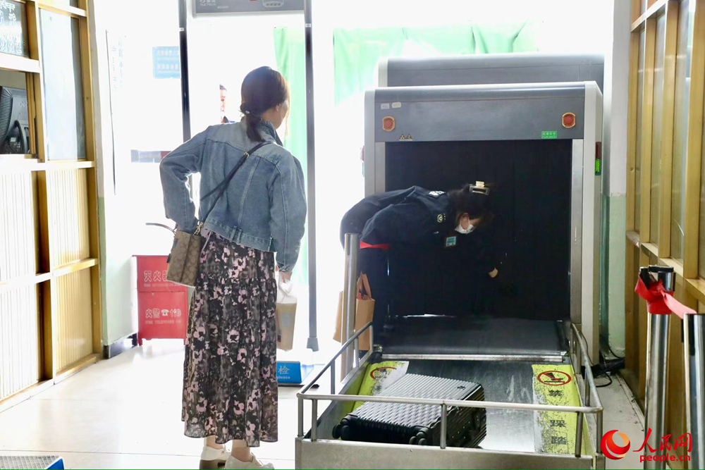 車站工作人員幫旅客提取行李。人民網(wǎng)記者 次仁羅布攝