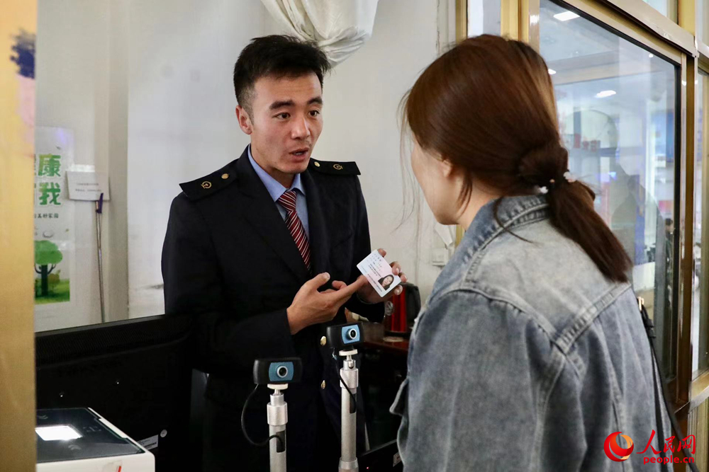 車站工作人員向旅客解答疑問。人民網(wǎng)記者 次仁羅布攝