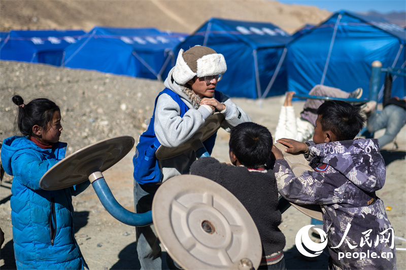 西藏星光社會工作服務中心社工久米旦增通過聊天談心，對孩子們進行災后心理疏導。人民網(wǎng)記者 翁奇羽攝