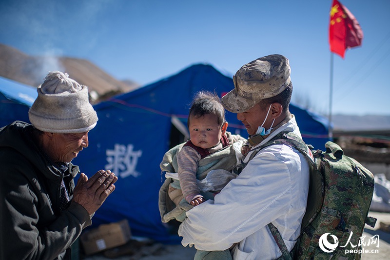 1月9日，在定日縣長所鄉(xiāng)古榮村安置點(diǎn)，受災(zāi)群眾感謝西藏軍區(qū)陸軍某部隊(duì)衛(wèi)生員的醫(yī)療救治。人民網(wǎng)記者 翁奇羽攝